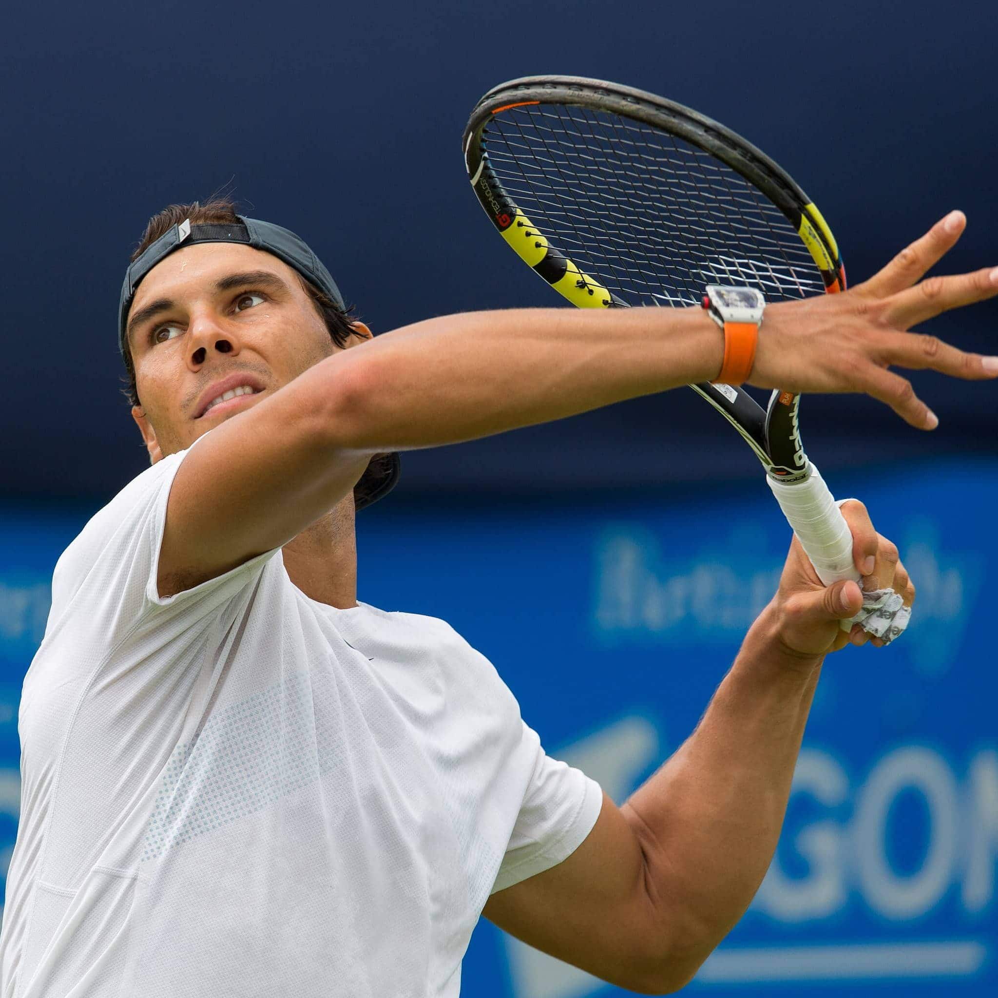 Rafael Nadal preparing to hit a tennis ball with focus and strength.