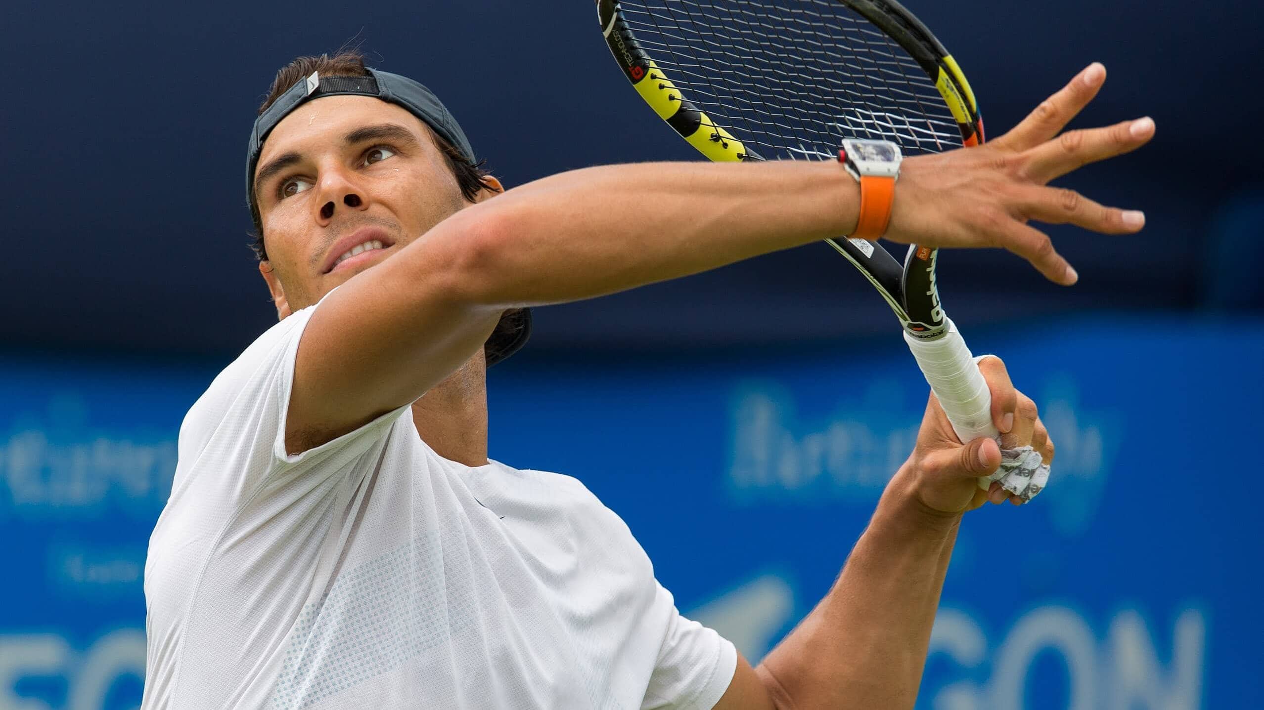 Rafael Nadal preparing to hit a tennis ball with focus and strength.