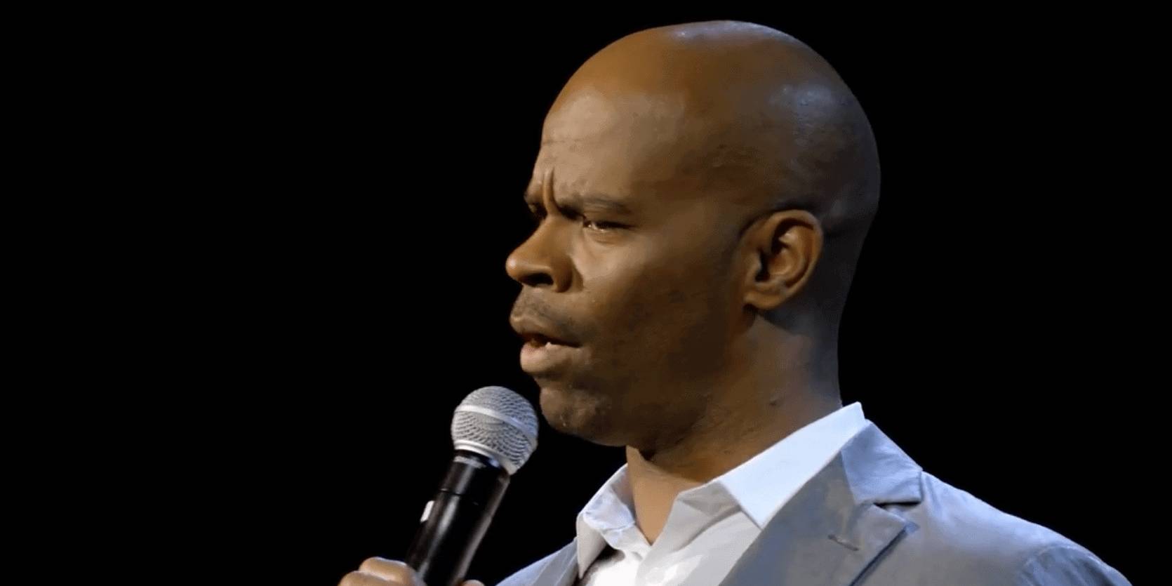 Rich black man speaking into microphone during presentation or conference.