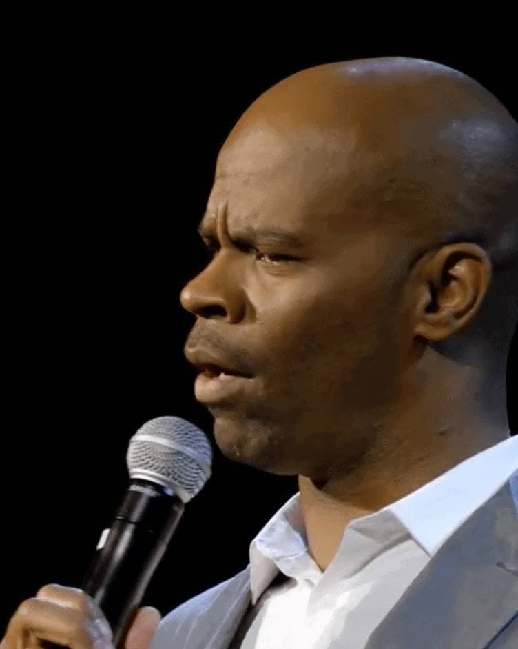 Rich black man speaking into microphone during presentation or conference.