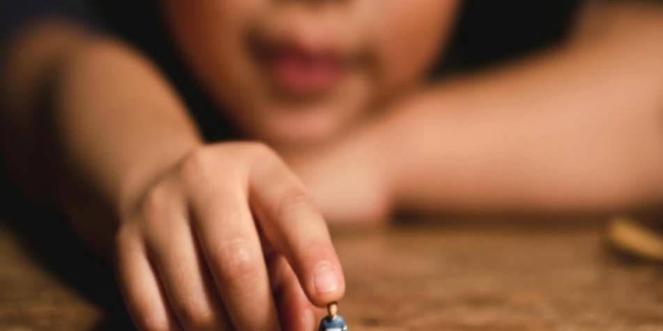 Child holding a tiny figurine, symbolizing strength and perspective.