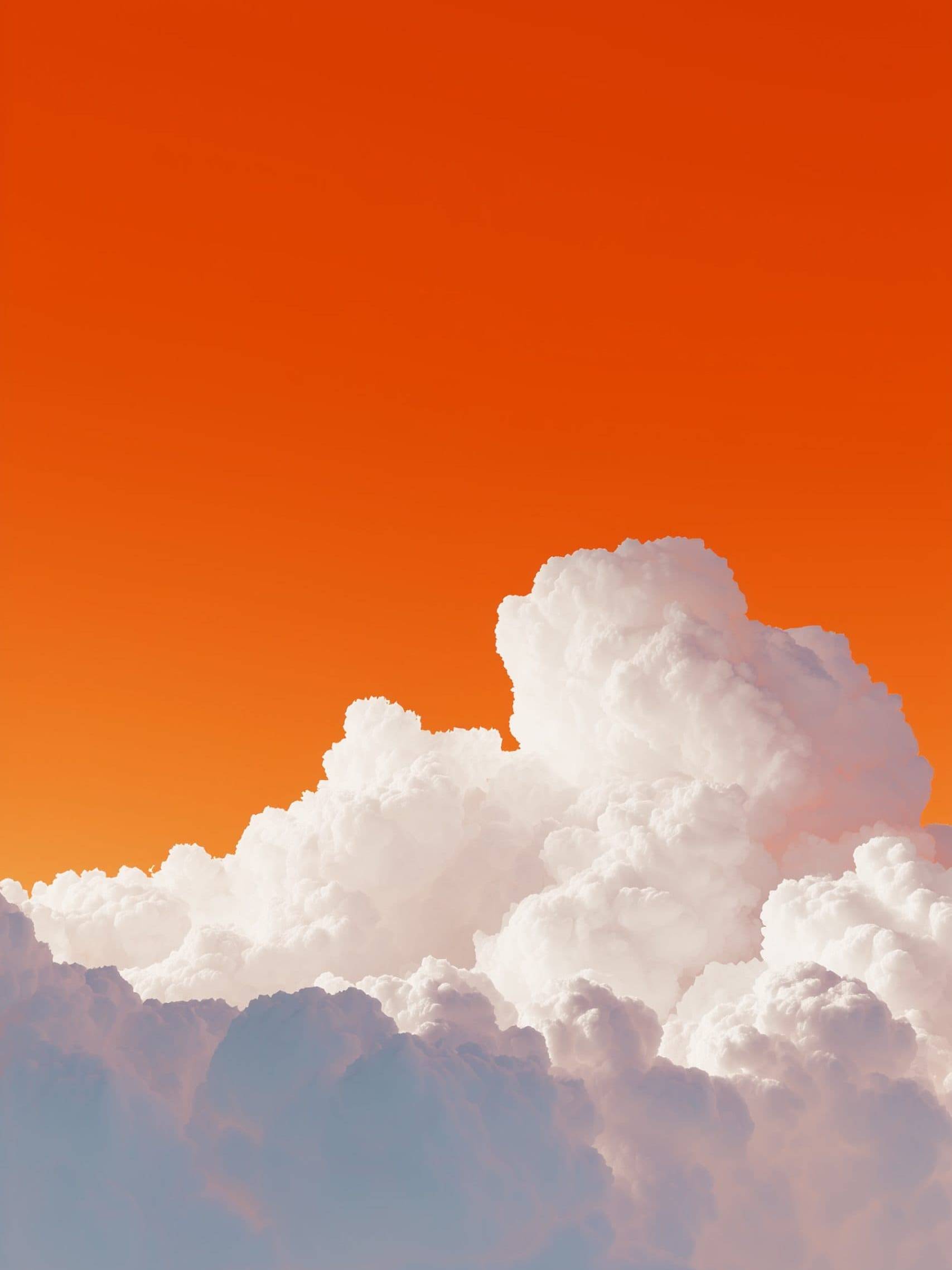 Beautiful white clouds against an orange sunset sky.