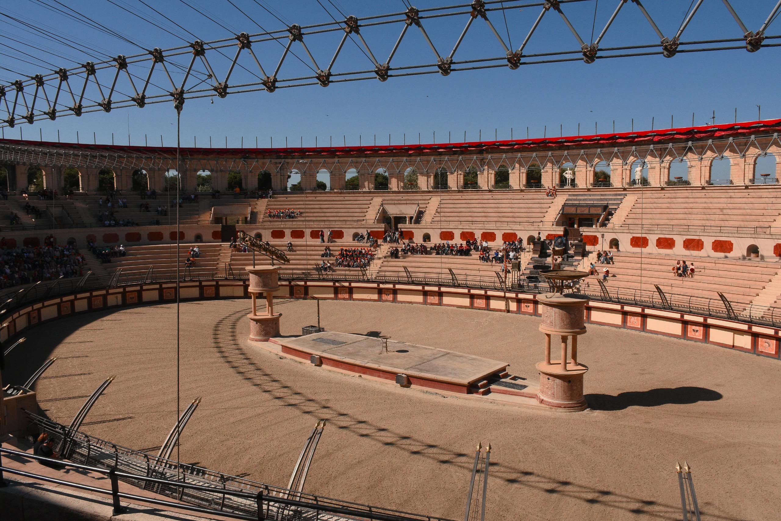 Ancient Roman-style amphitheater with open-air design and seating for spectators.