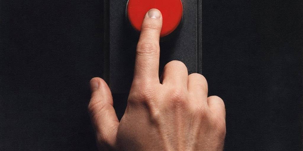 Hand pressing red button symbolizing emotional control and inner shift.