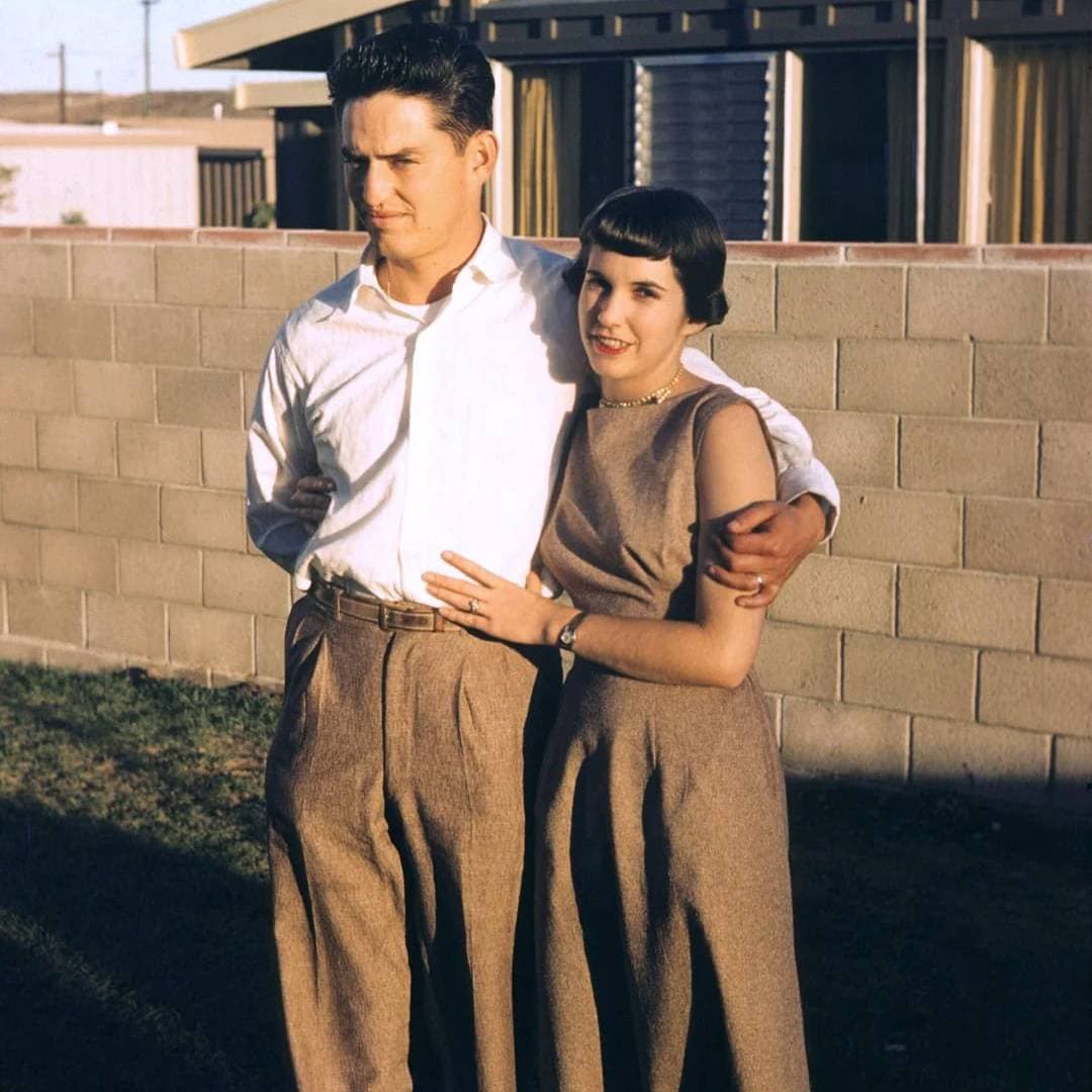 Vintage couple embracing outdoors in a nostalgic scene.