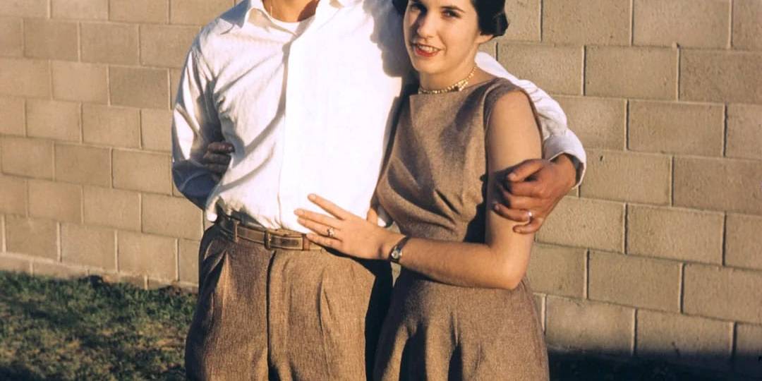 Vintage couple embracing outdoors in a nostalgic scene.