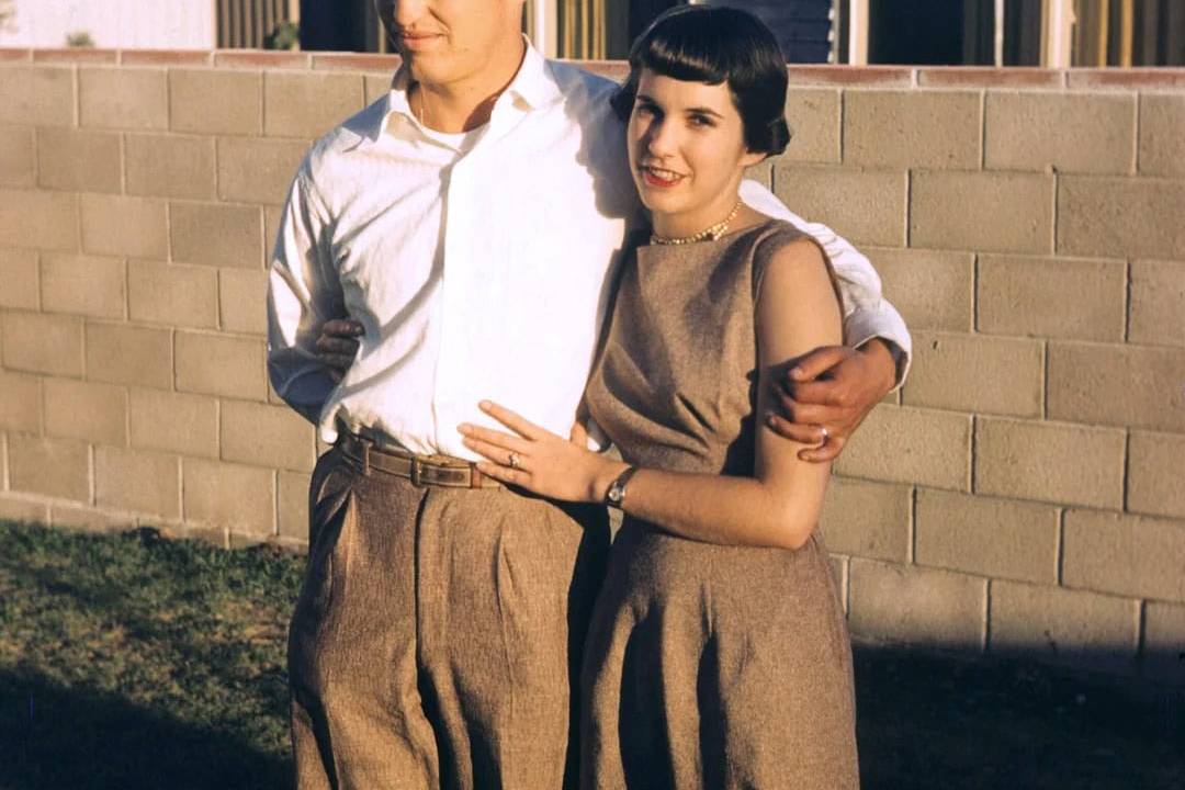 Vintage couple embracing outdoors in a nostalgic scene.