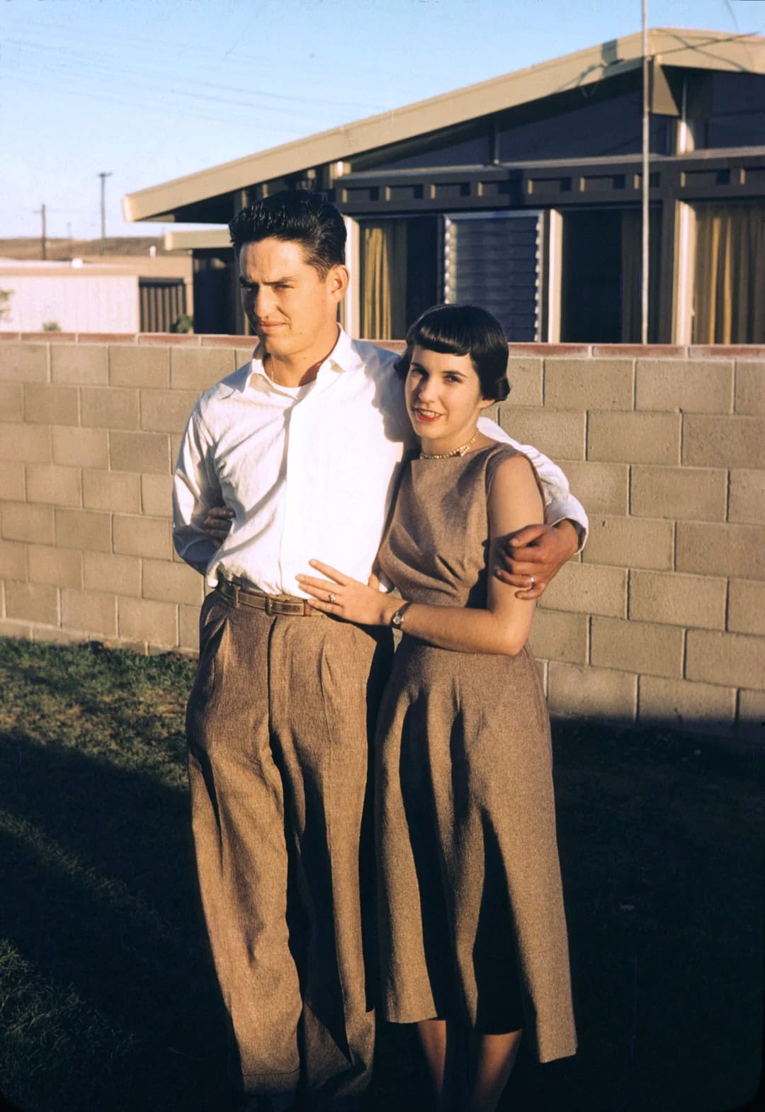 Vintage couple embracing outdoors in a nostalgic scene.