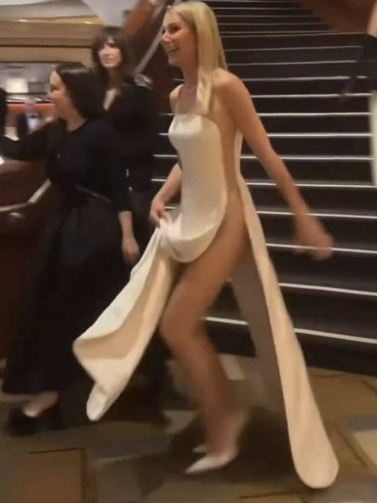 Celebrity on the red carpet wearing a daring gown with a dramatic train at The Naked Red Carpet even.