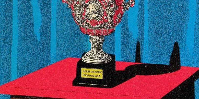 Elegant silver trophy with ornate handles on a red table.