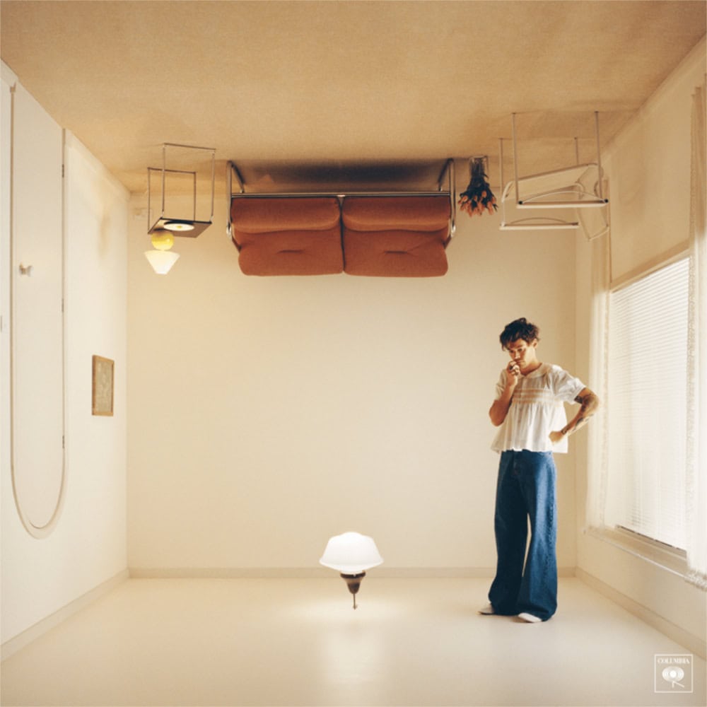 Upside-down furniture in a minimalist room with a woman pondering, creating a surreal, thought-provo.