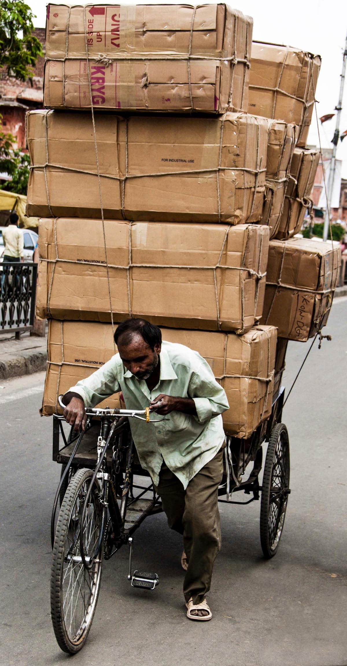 Cardboard boxes stacked on a bicycle cart, symbolizing burden and responsibility.