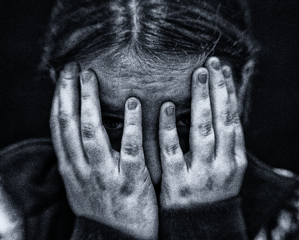Woman covering her face in distress, symbolizing shame and emotional pain.