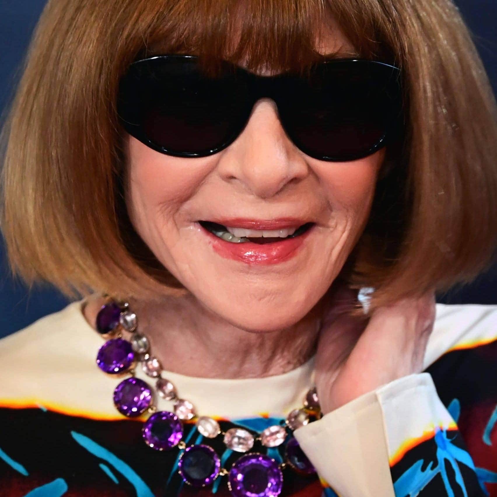 Elegant woman with sunglasses and statement jewelry at the Met Gala.