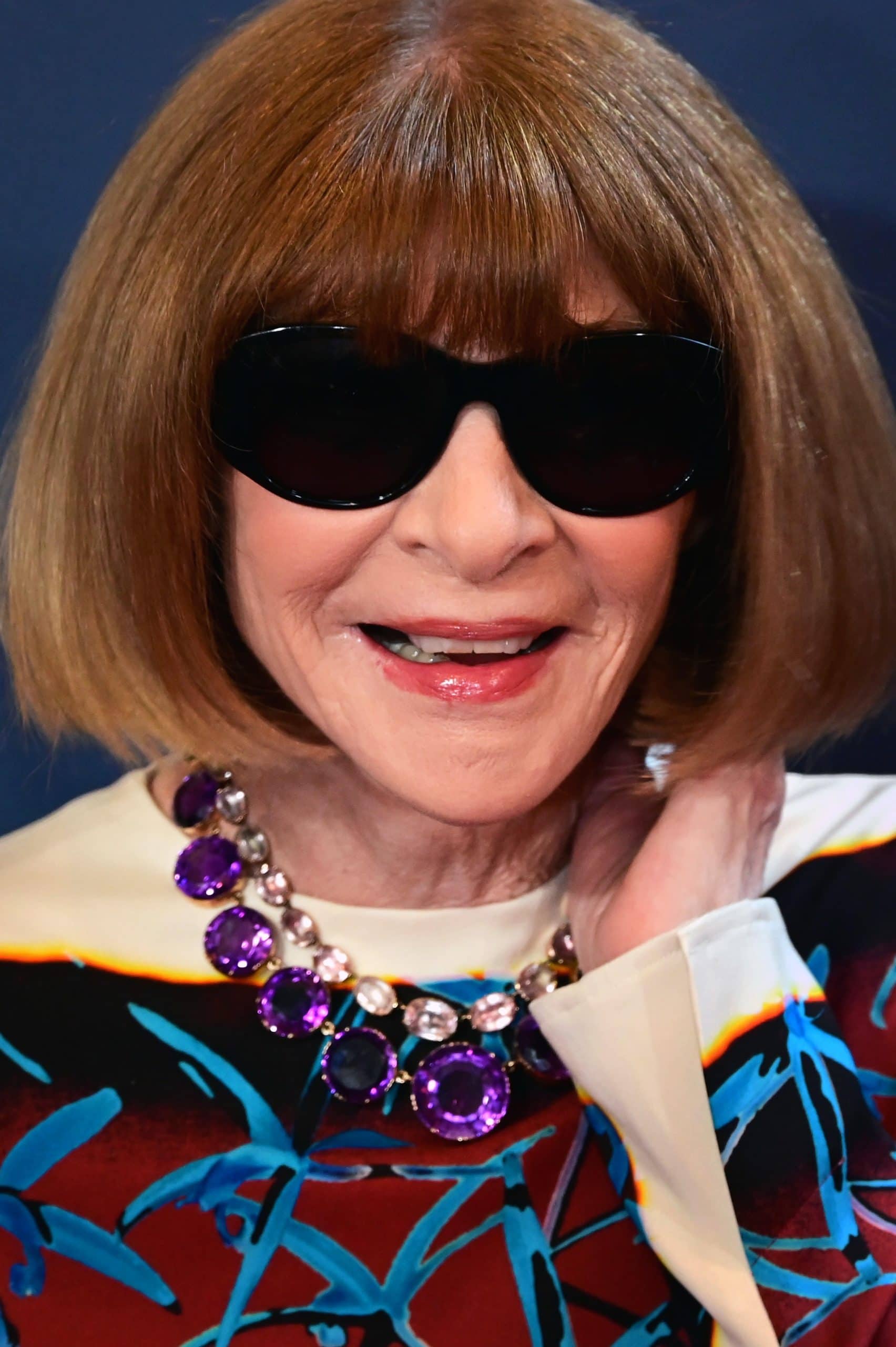 Elegant woman with sunglasses and statement jewelry at the Met Gala.