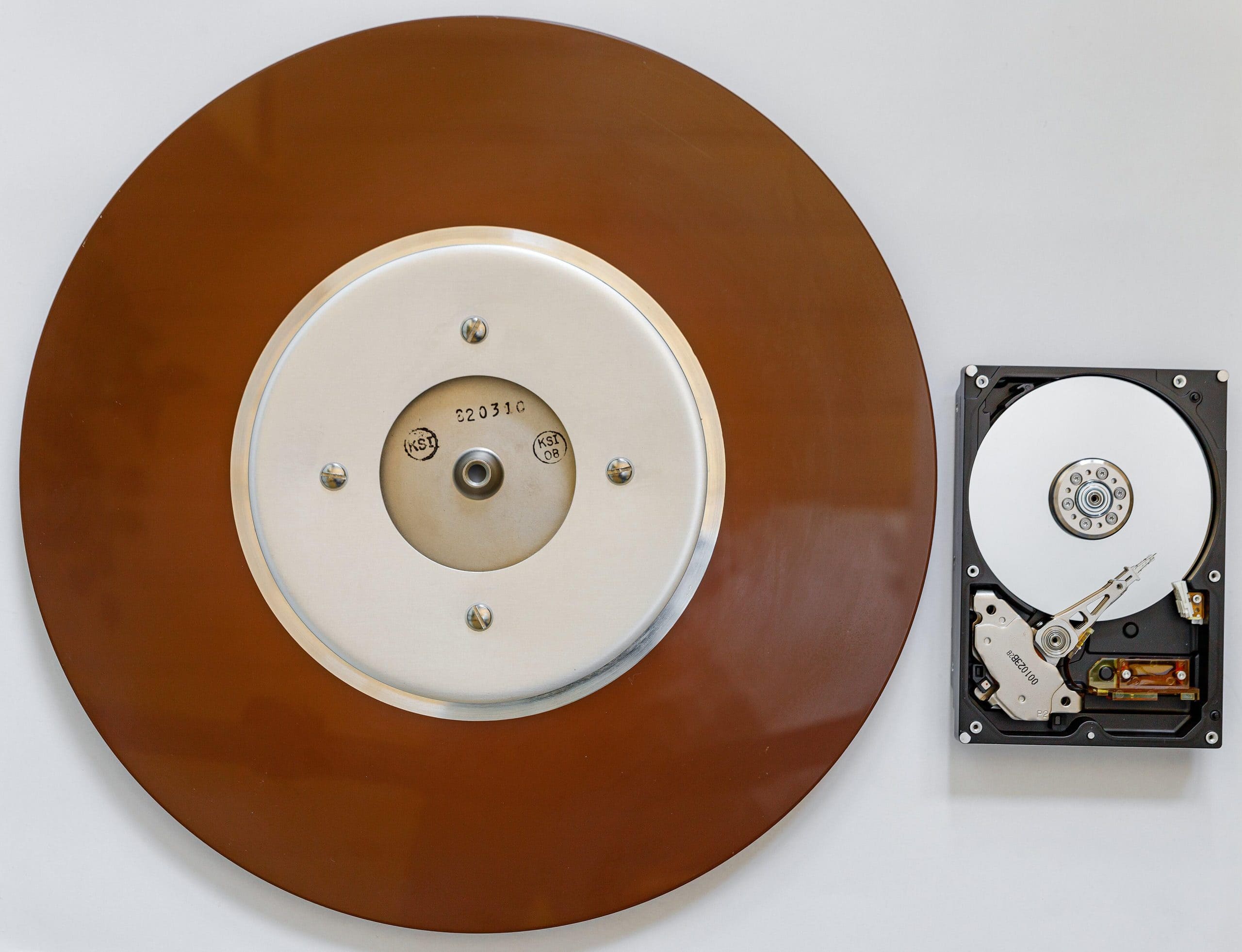 Vintage vinyl record and modern hard drive side by side, symbolizing the contrast between high and l.