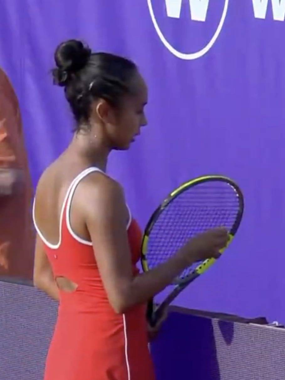 Female tennis player in red sportswear holding a tennis racket.