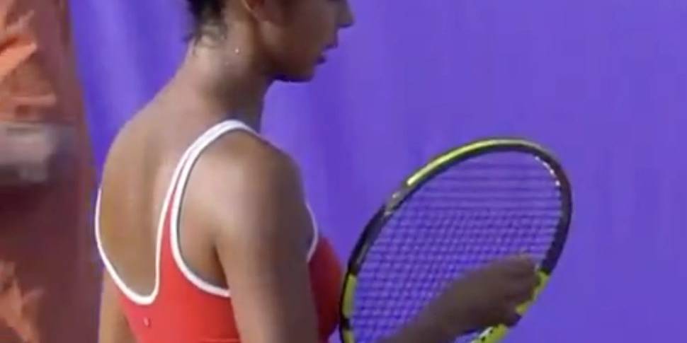Female tennis player in red sportswear holding a tennis racket.