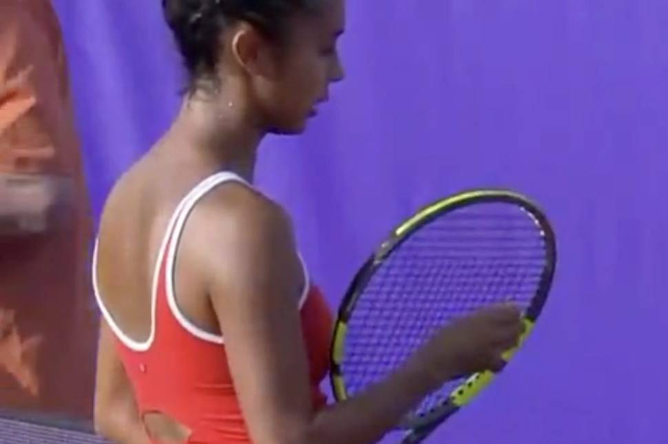 Female tennis player in red sportswear holding a tennis racket.