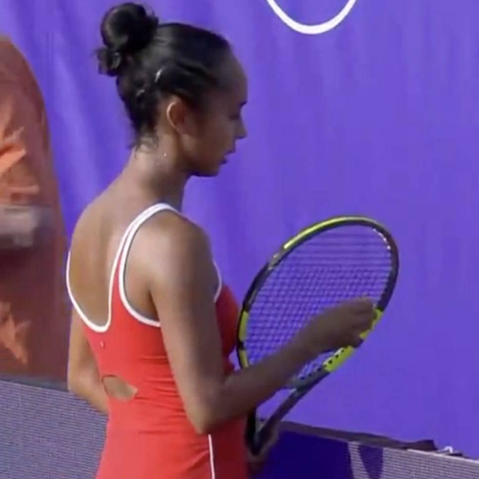 Female tennis player in red sportswear holding a tennis racket.
