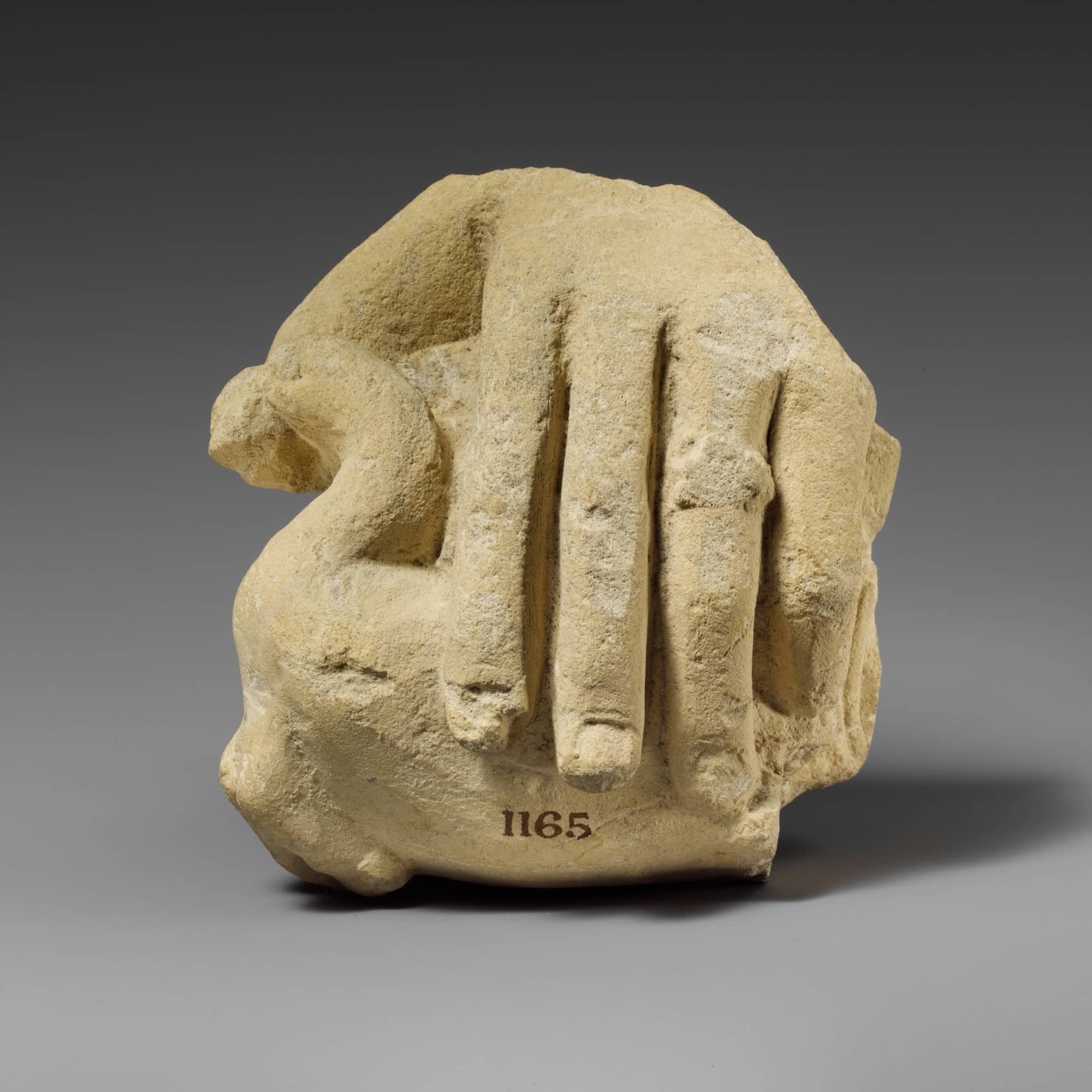 Close-up of an ancient carved stone with a hand motif, from the