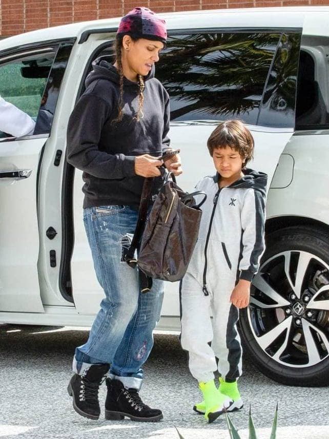 Halle Berry and her daughter standing next to a white SUV.