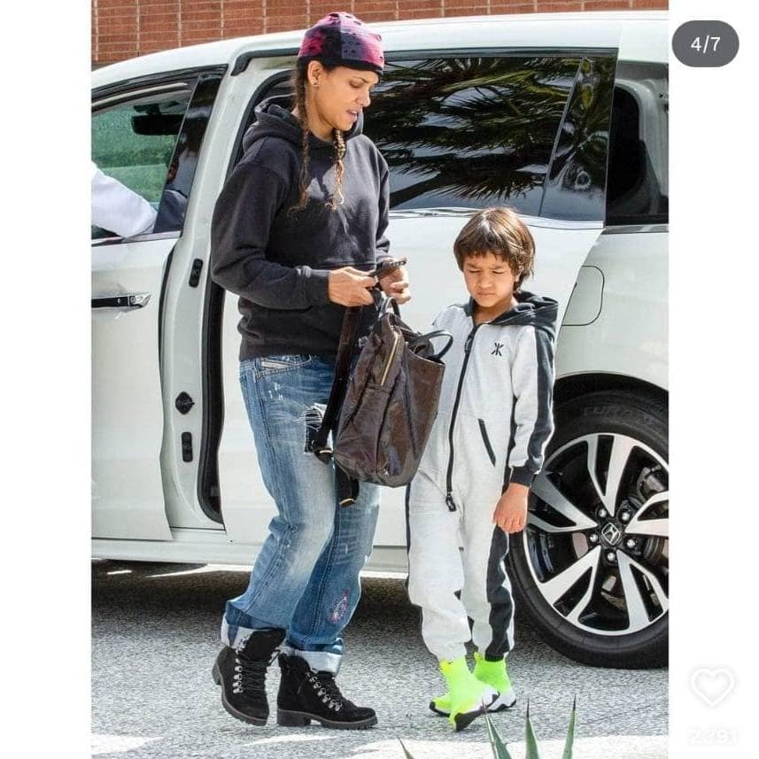 Halle Berry and her daughter standing next to a white SUV.
