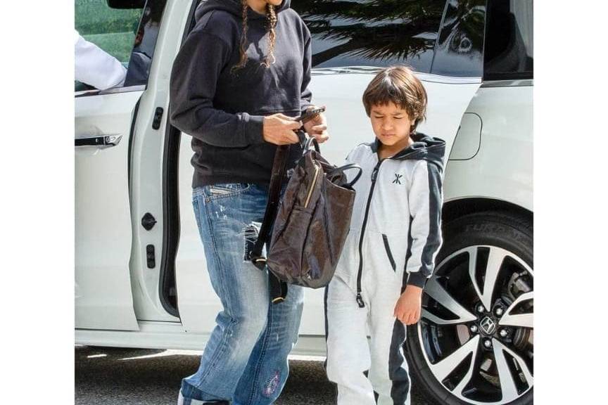 Halle Berry and her daughter standing next to a white SUV.